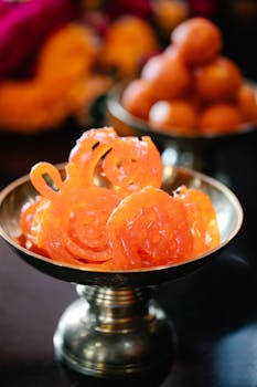 Close-up of Indian sweets Jalebi and Gulab Jamun in a brass bowl, ideal for cultural and food imagery.
